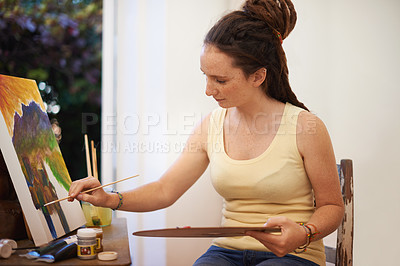 Buy stock photo A cropped shot of a woman painting on canvas at home