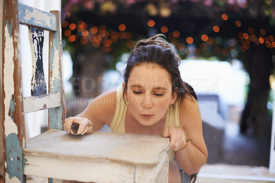 Buy stock photo A young woman sanding down an antique chair