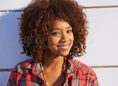 Buy stock photo A trendy young woman smiling while looking at the camera