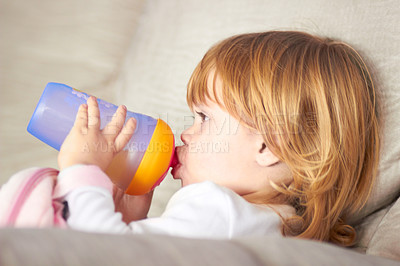 Buy stock photo Shot of an adorable little girl drinking from a sippy cup