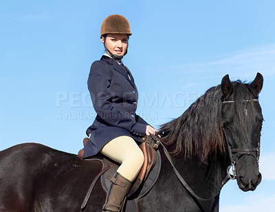 Buy stock photo Shot of a beautiful young woman riding her horse