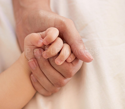 Buy stock photo Parent, baby and holding hand for comfort on bed for love, trust or support in bond. Person, infant and caring with touch for child development, growth or health in wellness for quality time together