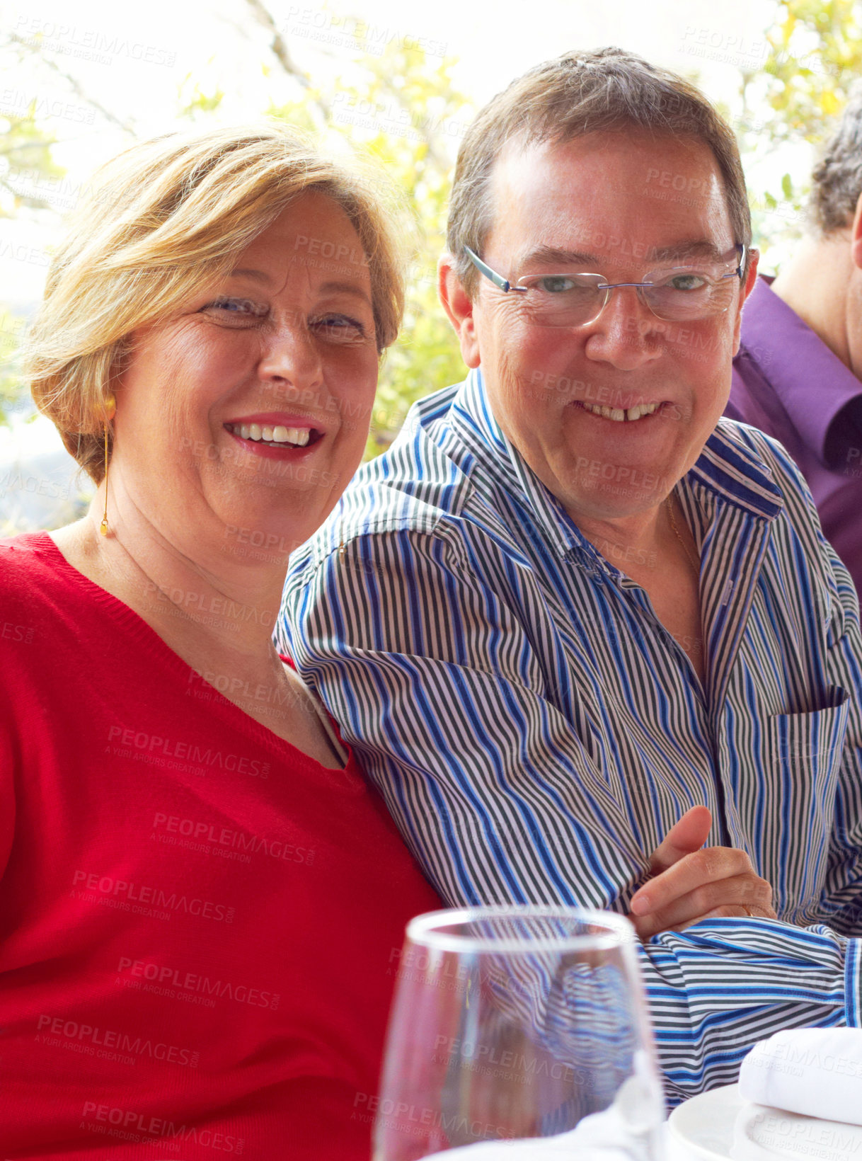 Buy stock photo Portrait of a happy mature couple sitting in a restaurant. Cheerful smiling aged couple relaxing at outdoor cafe table. Portrait of romantic aged man and woman on a date or at a party 