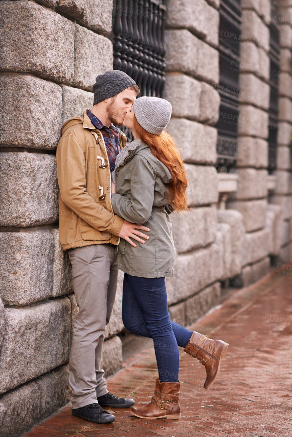 Buy stock photo Couple, love and kiss with affection outdoor at sidewalk or against wall in cold weather, together and support in London. Relationship, date and bonding for romance with commitment, care and happy