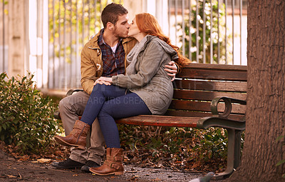 Buy stock photo Couple, love and sitting with kiss at park in cold weather or winter, together and support in London. Relationship, commitment and bonding for romance with soulmate, care and happiness with affection