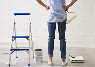 Buy stock photo Cropped rearview shot of a woman holding a paint roller
