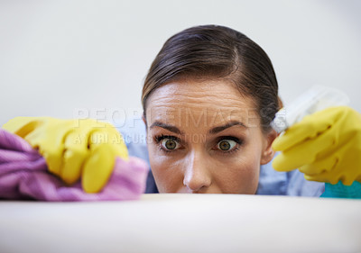 Buy stock photo Shot of a young woman shocked by the dirt she is finding around her house.