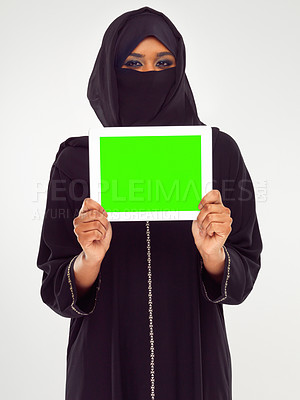 Buy stock photo Muslim woman, tablet and green screen for marketing, advertising or mockup against a grey studio background. Portrait of woman in hijab holding touchscreen with green chromakey screen or display