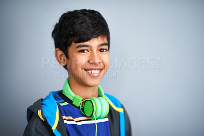 Buy stock photo Child, portrait and headphones for music listening as school student for podcast, track or entertainment. Boy, face and streaming audio in studio on grey background for media, radio or mockup space