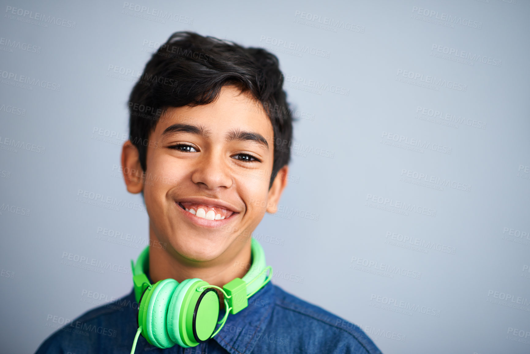 Buy stock photo Child, portrait and smile with headphones for music entertainment as school student for podcast, track or listening. Boy, face and streaming audio in studio on grey background, radio or mockup space