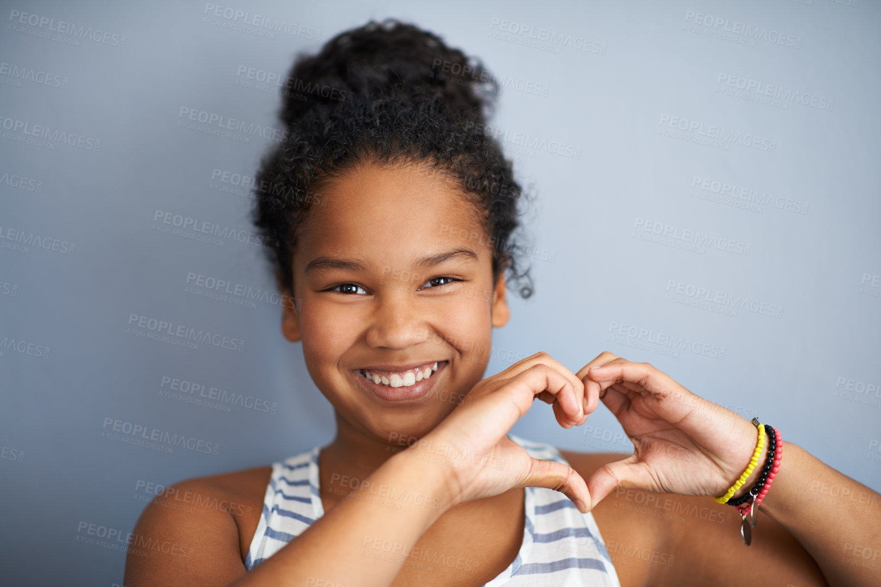 Buy stock photo Girl, portrait and heart shape with hands in studio for love, happiness and happy by grey background. Female, child and smile face with care sign for charity, donation and symbol to support or health