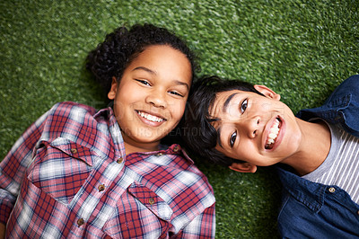 Buy stock photo Kids, brother and sister on grass, above and portrait with smile, bonding and relax in backyard at family home. Children, boy and girl siblings with care, love and connection on vacation in spring