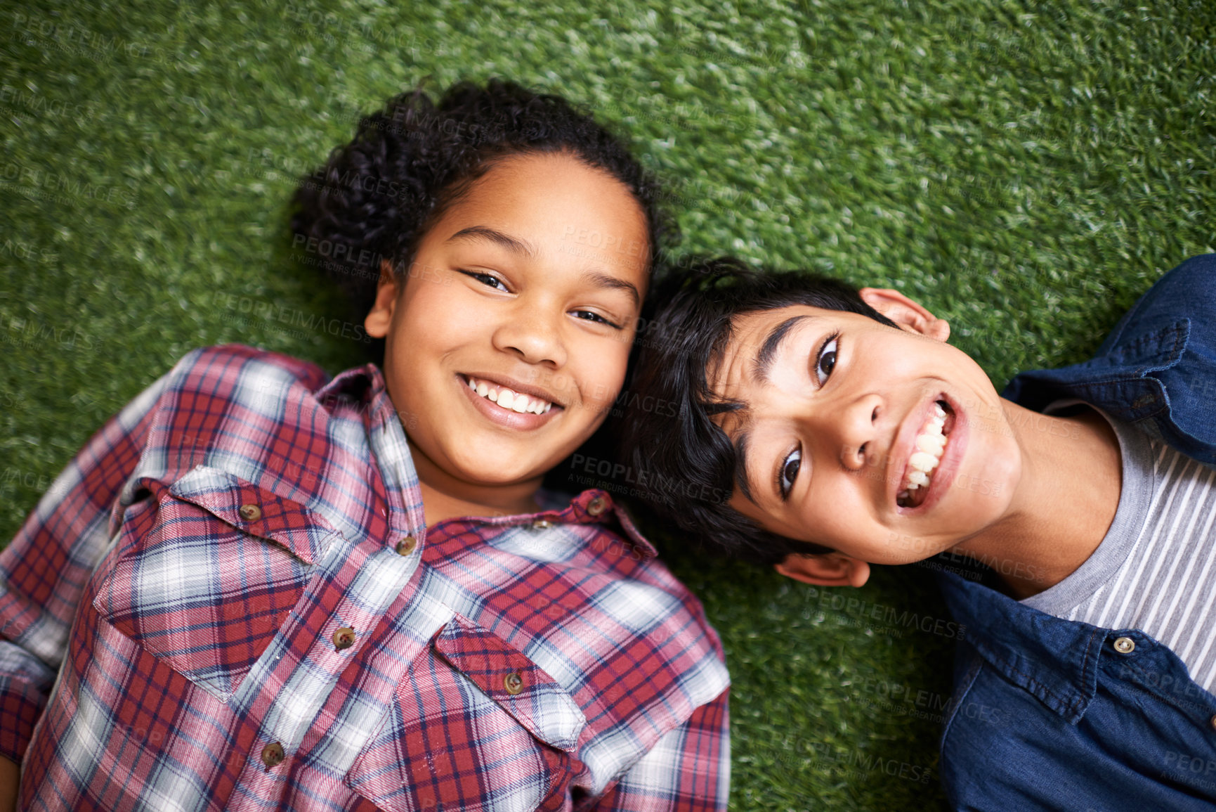 Buy stock photo Kids, brother and sister on grass, above and portrait with smile, bonding and relax in backyard at family home. Children, boy and girl siblings with care, love and connection on vacation in spring