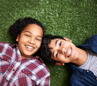 Buy stock photo Children, brother and sister on grass, above and portrait with smile, bonding and relax in backyard at family home. Kids, boy and girl siblings with care, love and connection on vacation in spring