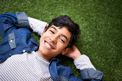 Buy stock photo A young boy relaxing on the lawn