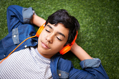 Buy stock photo Headphones, music and boy relax on grass with eyes closed outdoors on holiday, free time and weekend. Calm, peace and face of kid in garden listening to song, track and streaming audio for happiness