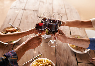 Buy stock photo Hands, group and wine glass for toast at table for celebration, food and friends at lunch event. People, together and celebrate with alcohol, glasses and support at party, dinner and family home