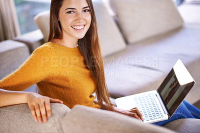 Buy stock photo A young woman on the couch with her laptop