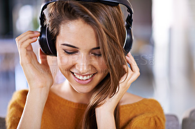 Buy stock photo Beautiful young woman listening to music at home