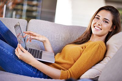 Buy stock photo Cropped shot of an attractive young woman relaxing on the sofa with her laptop