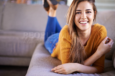 Buy stock photo Portrait of a beautiful young woman lying on a sofa at home