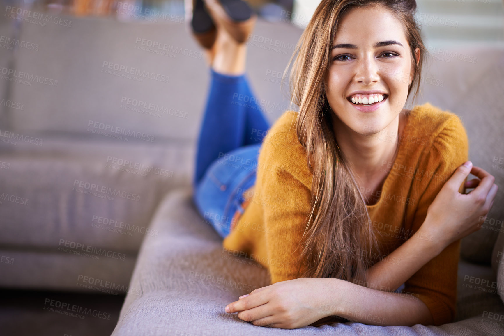 Buy stock photo Portrait of a beautiful young woman lying on a sofa at home