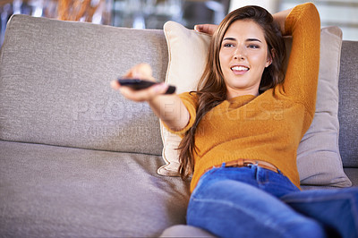 Buy stock photo Home, relax and woman with remote control, watching tv and happiness in a living room. Apartment, girl on a couch and person with entertainment or series with comedy movie and film with weekend break