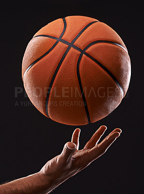 Buy stock photo Cropped image of a man's hand holding a basketball against a black background