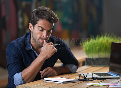 Buy stock photo A thoughtful young entrepreneur using his laptop 