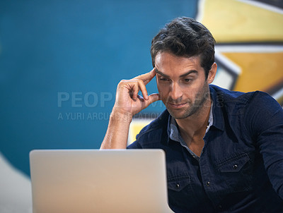 Buy stock photo A thoughtful young entrepreneur using his laptop