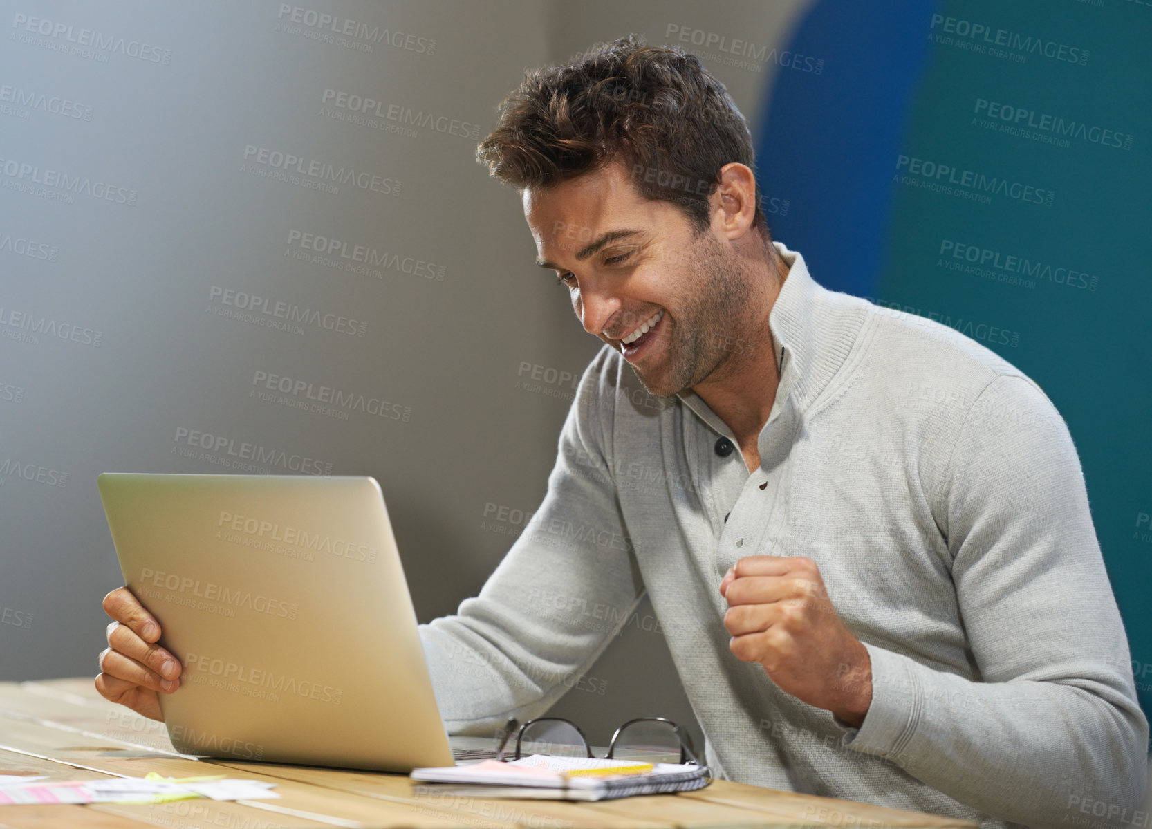 Buy stock photo A smiling entrepreneur using his laptop at a table