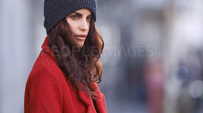 Buy stock photo Shot of a beautiful young woman in winter clothing standing in an urban setting