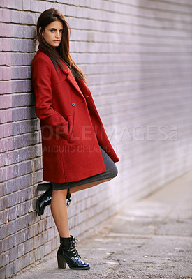 Buy stock photo Portrait of a gorgeous young woman leaning against a brick wall in the city