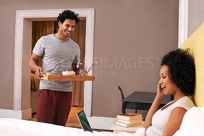 Buy stock photo A young man bringing his girlfriend breakfast in bed