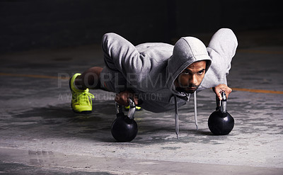 Buy stock photo Shot of a young man doing push-ups with kettle bell weights