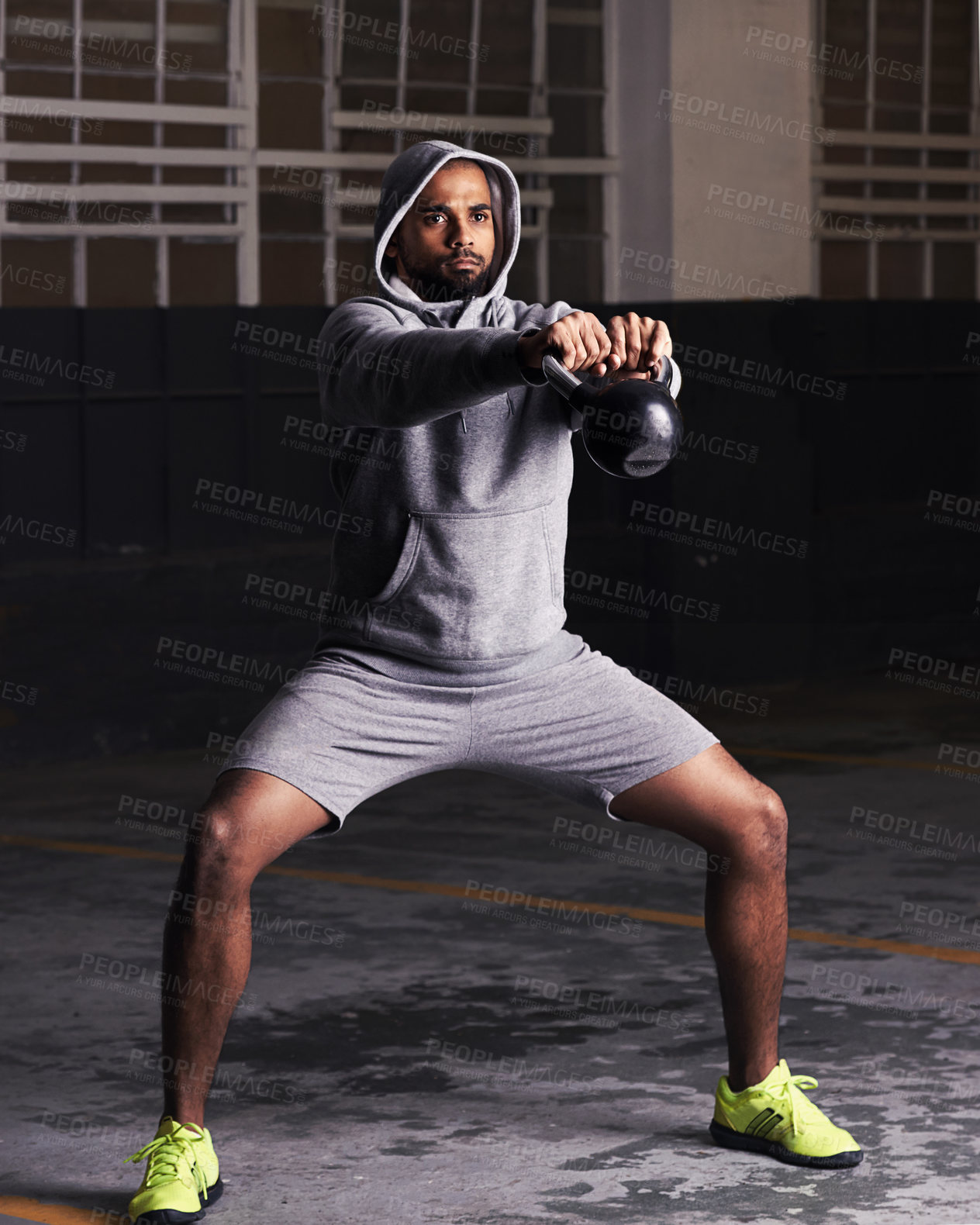 Buy stock photo Man, fitness and workout with kettlebell for training, muscle exercise and endurance in parking lot. Bodybuilder, serious face and equipment with weight for balance, strength and healthy body