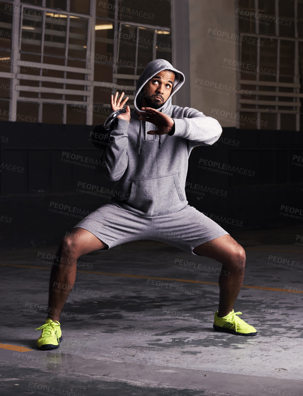 Buy stock photo Man, kettlebell and exercise in building with fitness for strength workout, squat and weightlifting in warehouse. Athlete, bodybuilder and muscle training with equipment for healthy body at night