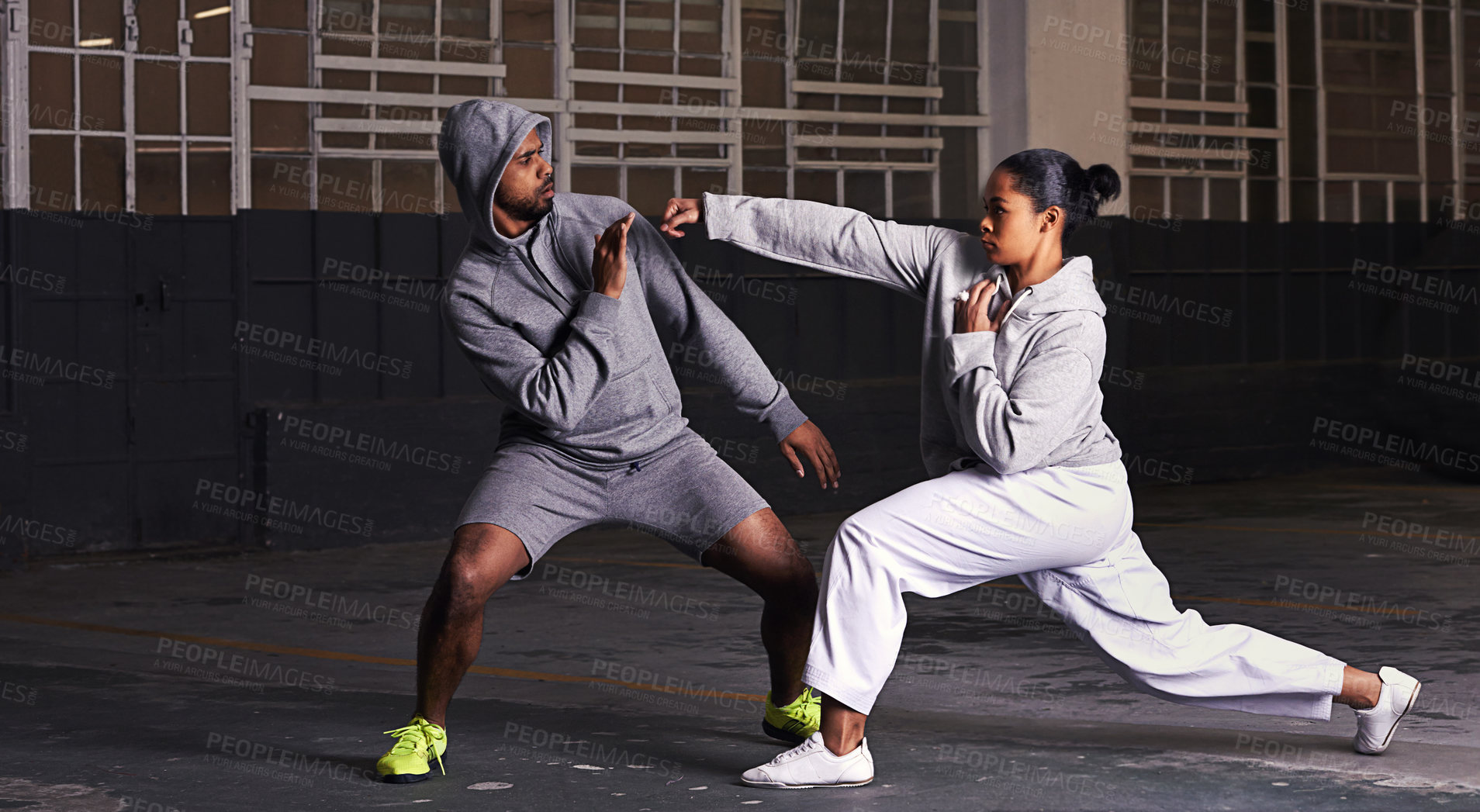 Buy stock photo A young man and woman doing fight training