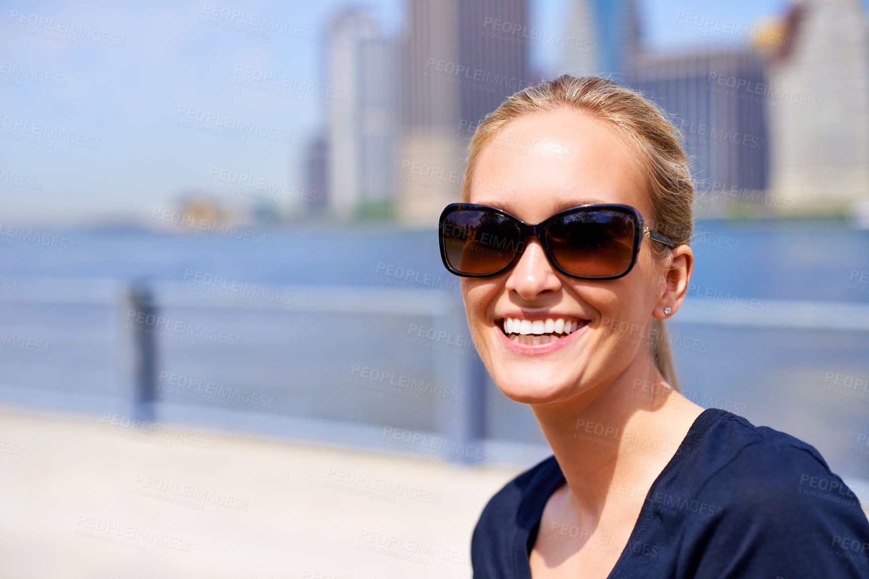 Buy stock photo Woman, happy and smile in city on holiday, sightseeing tourist and female person in New York. Blue sky ,travelling in summer with sunglasses in urban area, relaxing vacation and outdoor wellness