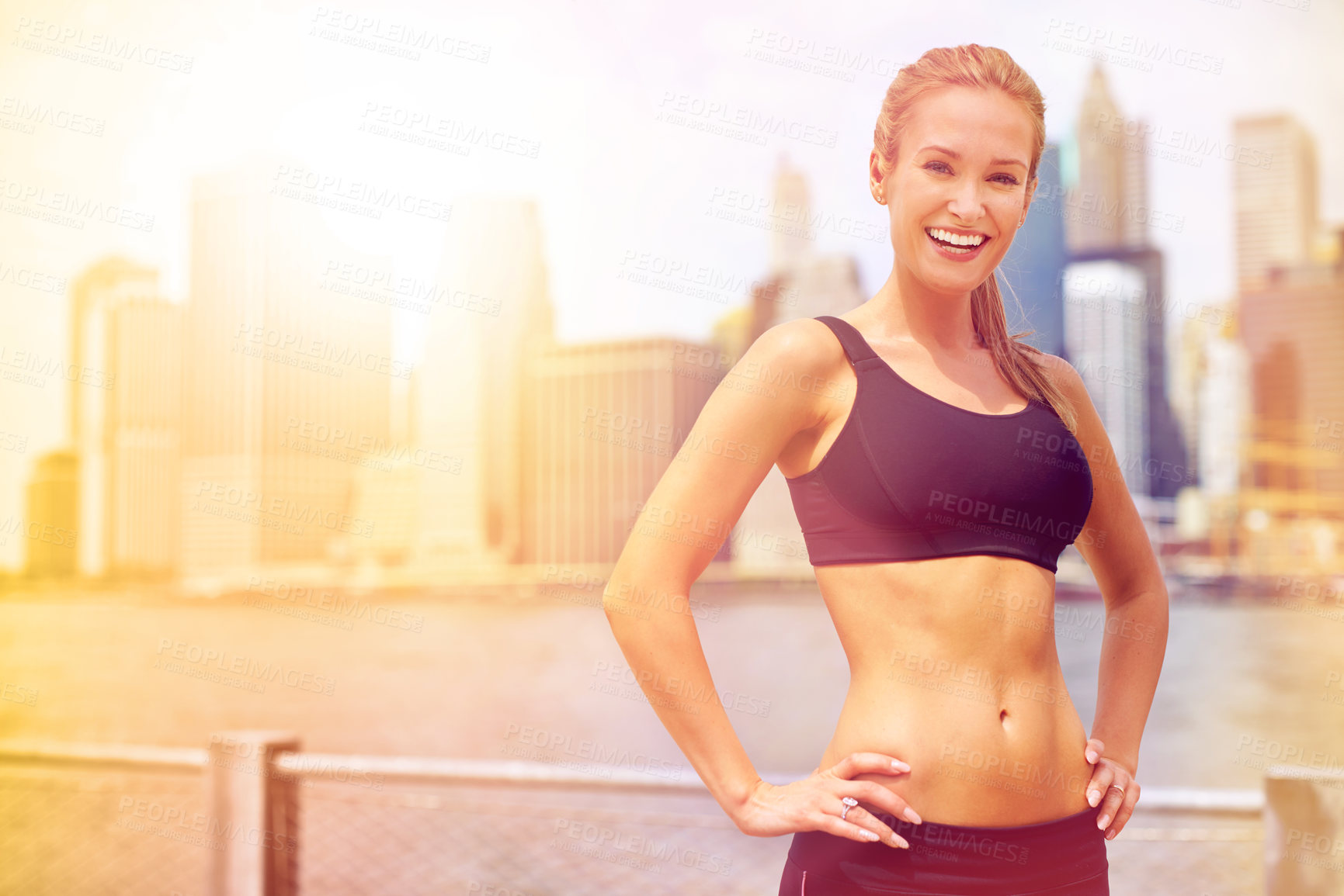 Buy stock photo Portrait of a beautiful young woman standing beside a river while out for a run in the city
