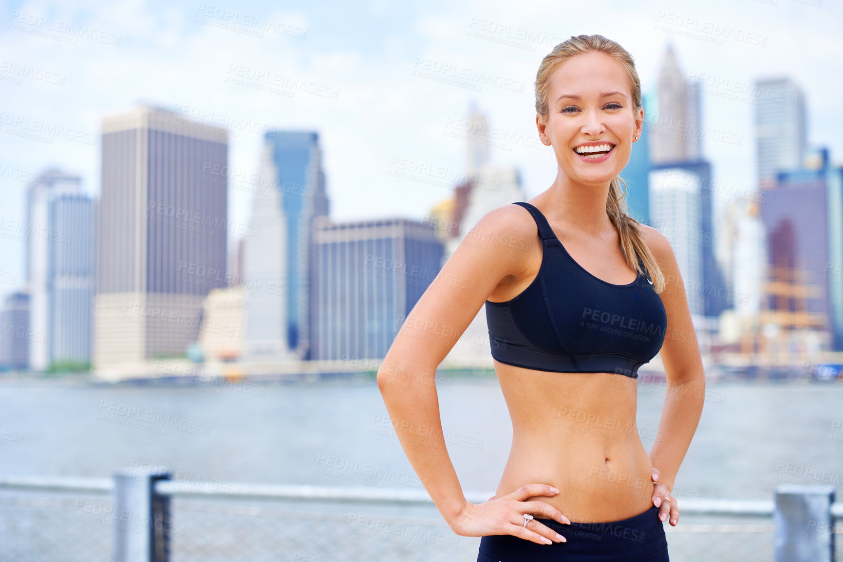 Buy stock photo Woman, city and smile at river in sportswear with break for jog, fitness and healthy mind in New York. Portrait, female person and happy with self care in summer, hot weather and confident

