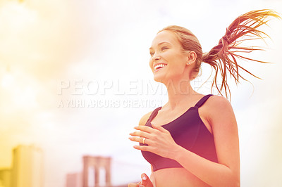 Buy stock photo Shot of an attractive blonde woman jogging in the city