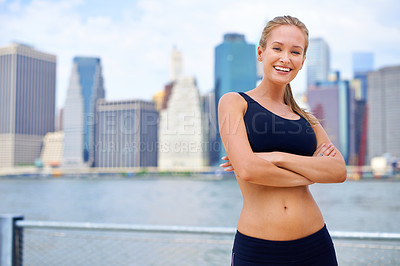 Buy stock photo Woman and smile at river side with city view on sport clothes to jog, fitness and healthy mindset in New York. Portrait, arms folded and female person with self care in summer, hot weather and happy