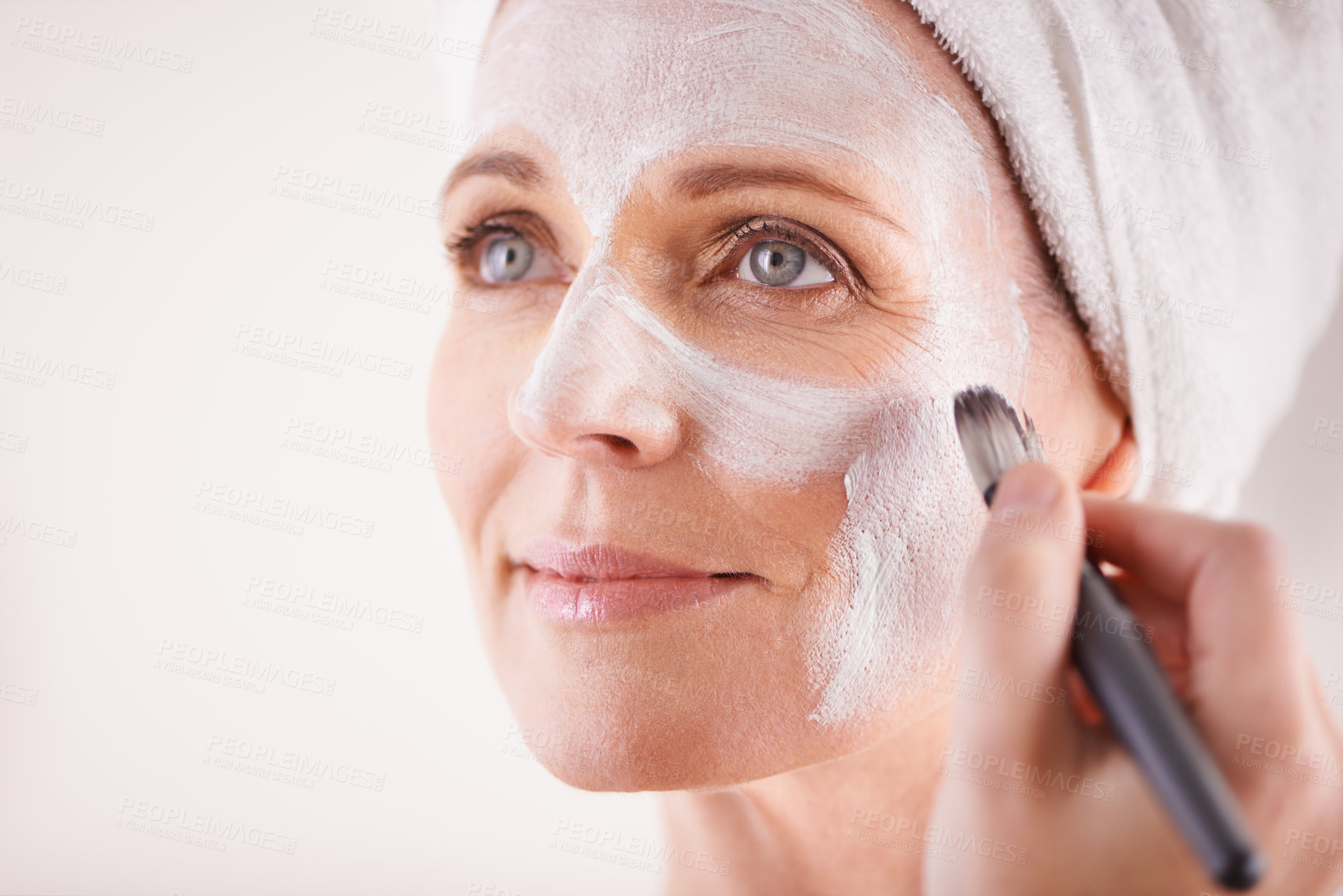 Buy stock photo Mature woman, face mask with brush for smile in studio for skincare or anti aging on self care, wellness and fresh skin. Closeup, female person and glow with happiness for facial and beauty or luxury