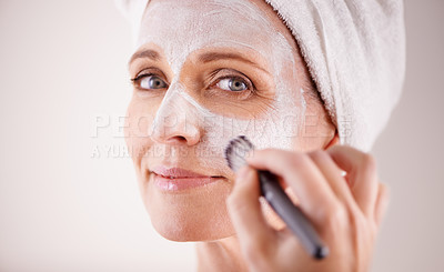 Buy stock photo Face, mature woman and mask with brush in studio for skincare or anti aging on self care, wellness and fresh skin. Closeup, female person and glow with smile or happy for facial and beauty for luxury