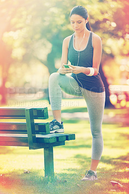 Buy stock photo Woman, exercise and listening to music in park, fitness and commitment or training for healthy body. Young lady, smartphone and runner with streaming audio, technology and morning workout in nature