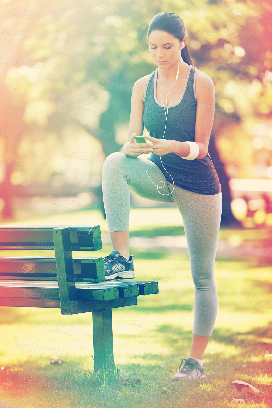 Buy stock photo Woman, exercise and listening to music in park, fitness and commitment or training for healthy body. Young lady, smartphone and runner with streaming audio, technology and morning workout in nature