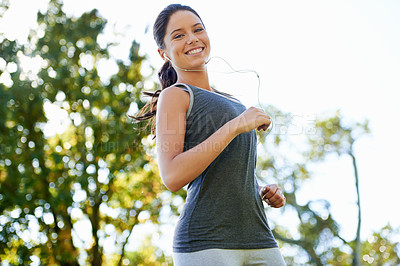 Buy stock photo Young woman, running and music in portrait in park, happy and streaming audio for exercise in nature. Lady, smile face or wellness with earphones for training, fitness or health in outdoor in summer