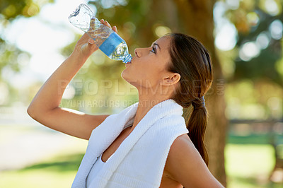 Buy stock photo Young woman, runner or drinking water in park for training exercise, sunshine or wellness in nature. Athlete, towel or health drink in bottle for hydration, fitness or workout performance by trees