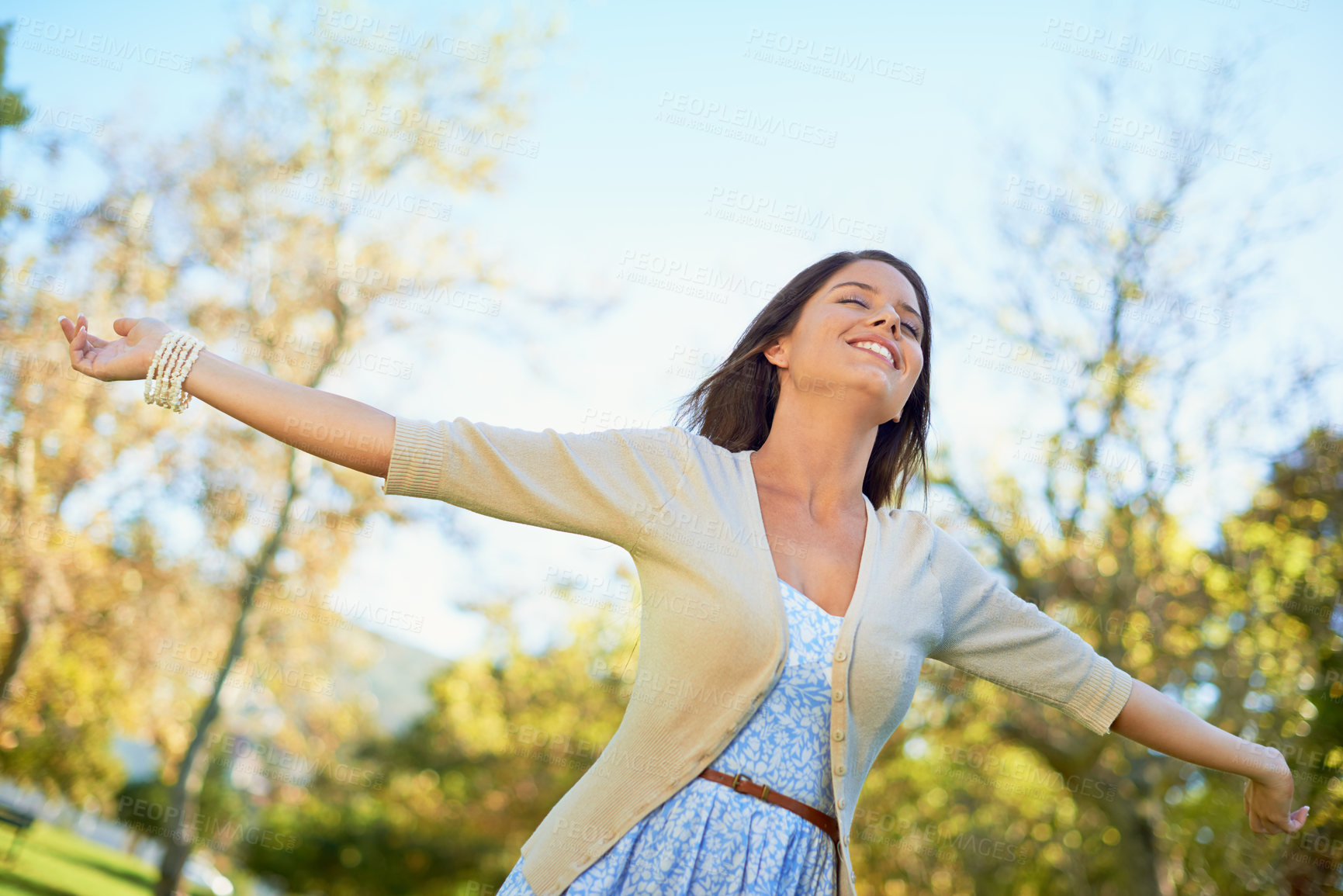 Buy stock photo Shot of a carefree young woman enjoying a day at the park